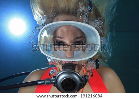 Female scuba diver underwater with water inside mask