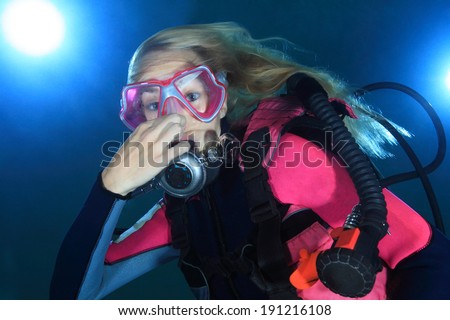 Portrait of female scuba diver underwater making pressure relase