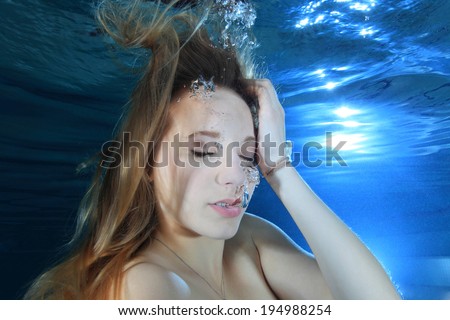 Portrait of young woman underwater in the pool