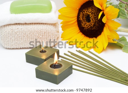 Relaxing spa scene with candles, incense sticks, body sponge, face towel and handmade glycerin soap