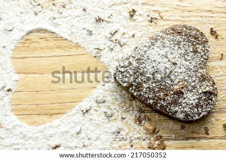 Chocolate heart cookies in powdered sugar and chocolate crumbs. And the place of another heart cookie.
