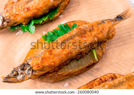 Fish and chips, fish in batter into slices of French fries on paper and newspaper