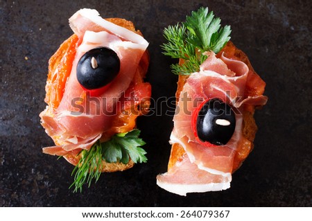 Spanish appetizer with jamon on a black background top view