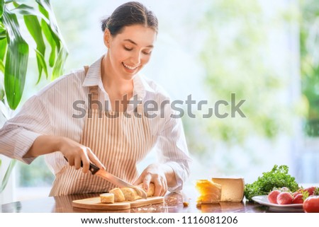 Similar – Image, Stock Photo Smiling woman cutting cheese for salad in kitchen