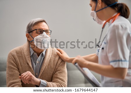 Doctor and senior man wearing facemasks during coronavirus and flu outbreak. Virus and illness protection, home quarantine. COVID-2019