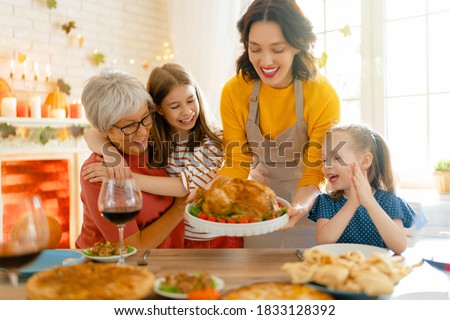 Happy Thanksgiving Day! Autumn feast. Family sitting at the table and celebrating holiday. Traditional dinner. Grandmother, mother and daughters.
