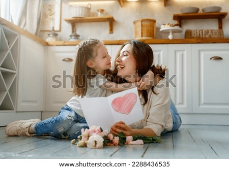 Similar – Image, Stock Photo Child daughter congratulates mother and gives present card, gift and bouquet of flowers at home. Mom and girl smiling and hugging on couch. Happy mothers day celebration