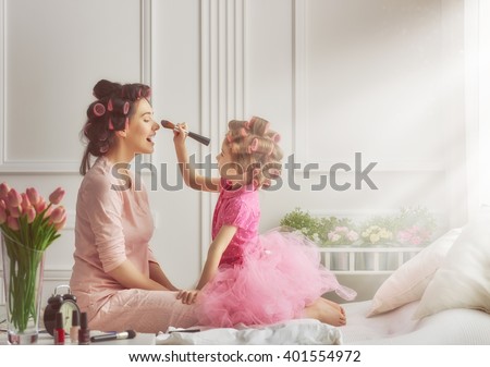 Similar – Image, Stock Photo Mom and little daughter are sitting on the bed and playing with dolls. Motherhood, caring, time together