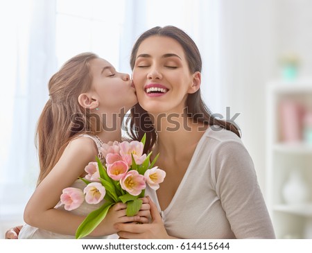 Similar – Image, Stock Photo Child daughter congratulates mother and gives present card, gift and bouquet of flowers at home. Mom and girl smiling and hugging on couch. Happy mothers day celebration