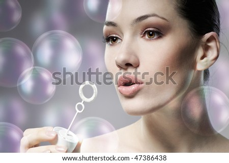 a beauty young woman blowing soap bubbles