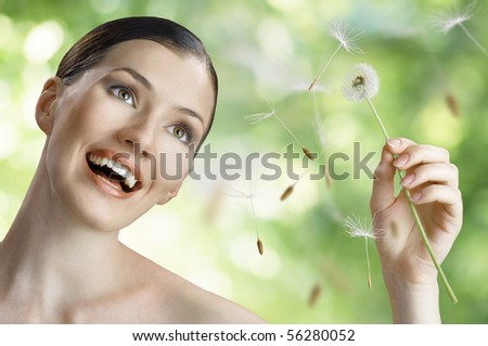 beautiful smiling girl with dandelion in hand