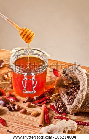 Honey dripping into a jar next to some coffee beans