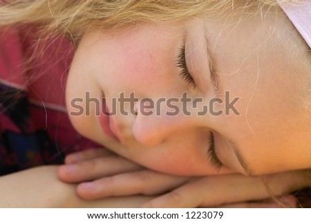 close-up of a beautiful young girl sleeping and dreaming outside in the garden