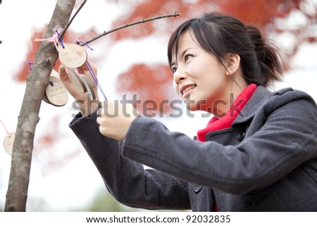 asian woman blessing with autumn tree background taken in Korea