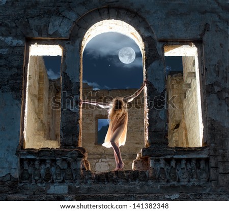 Mysterious female figure standing in the arc of the ruined building in full moon night