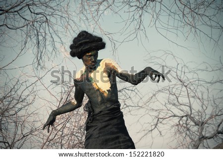 Earth spirit. Portrait of a guy in body paint with the tree's branches