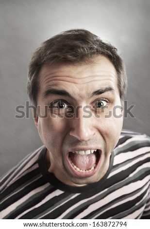 Man screams opening the mouth, close-up shot, abstract background, view from above