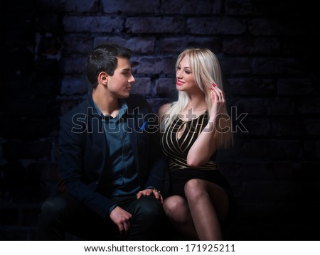 Young flirting couple, dark background