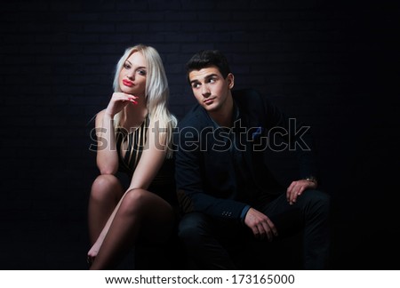 Portrait of a young flirting couple, dark background