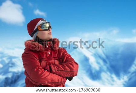 Woman in ski glasses looking away, mountains in the background