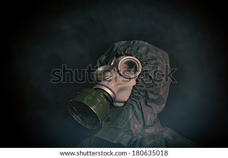 Portrait of soldier in chemical protection armor and gas mask looking up