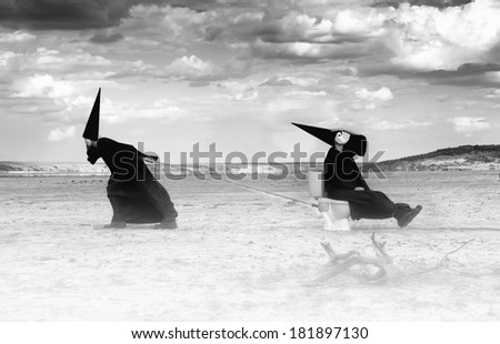 Two strange persons in black cloaks traveling in the desert