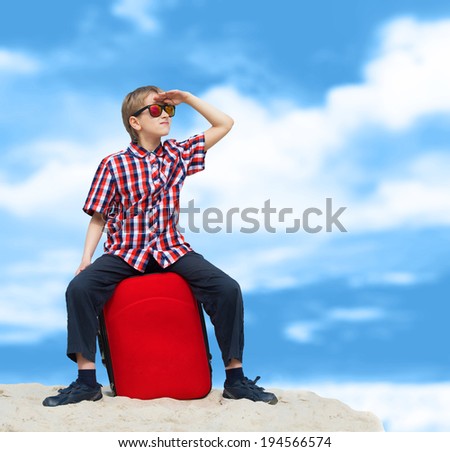 Portrait of a lost boy with his luggage, tropical beach background