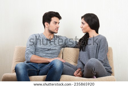 Young happy couple talking together sitting on a sofa