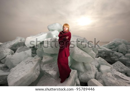 Woman in red cape against blocks of ice