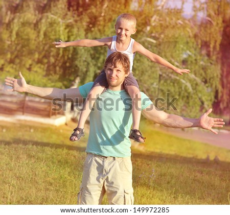 Family Father Man and Son Boy sitting on shoulders playing Outdoor park Happiness emotion with summer nature on background