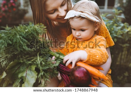 Mother and daughter child with organic vegetables healthy eating lifestyle vegan food homegrown beet and carrot local farming grocery shopping agriculture concept