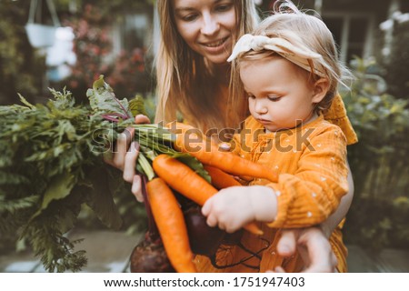 Mother and child daughter with organic vegetables healthy food family lifestyle homegrown beet and carrot local farming gardening vegan nutrition concept