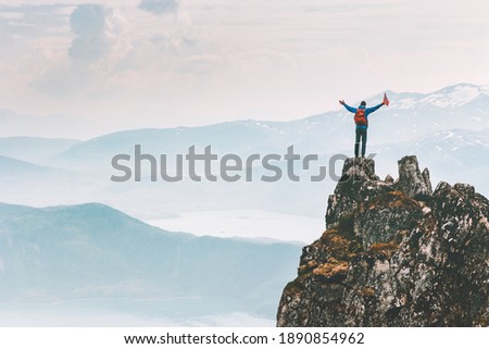 Man climber on mountain cliff summit traveling hike in Norway adventure vacations outdoor extreme activity healthy lifestyle traveler success raised hands Husfjellet peak  Сток-фото © 