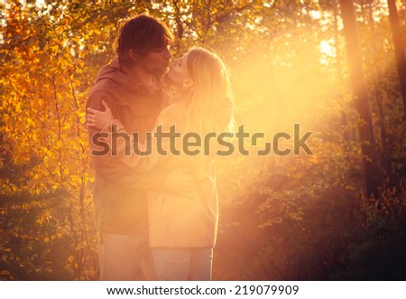 Young Couple Man and Woman Hugging and Kissing in Love Romantic Outdoor with sun light Autumn nature on background Fashion trendy style