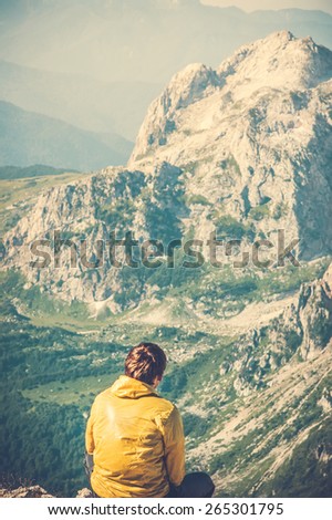Man Traveler relaxing alone in Mountains with beautiful summer landscape on background mountaineering sport lifestyle concept
