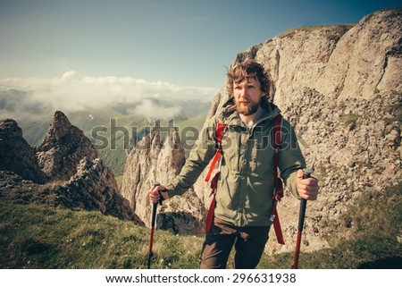 Young Man with backpack hiking outdoor Travel Lifestyle survival concept with rocky mountains on background Summer vacations