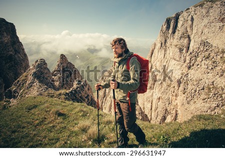 Young Man with backpack hiking outdoor Travel Lifestyle survival concept with rocky mountains on background Summer vacations