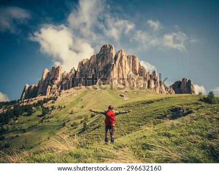 Young Man with backpack raised hands relaxing outdoor Travel Lifestyle hiking concept with rocky mountains on background Summer vacations