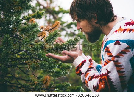 Man hands holding fir tree branch Travel Lifestyle survival concept outdoor forest nature on background