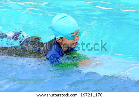 Portrait of four years old boy with swimming accessories