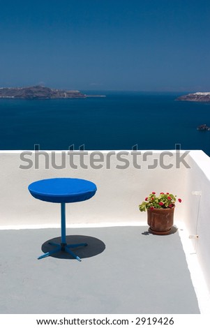 View from the balcony to Aegean Sea. Blue table and plant in vase standing on this balcony.