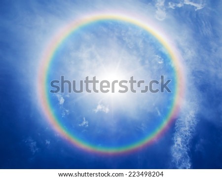 rainbow halo around the sun in the blue sky backgound