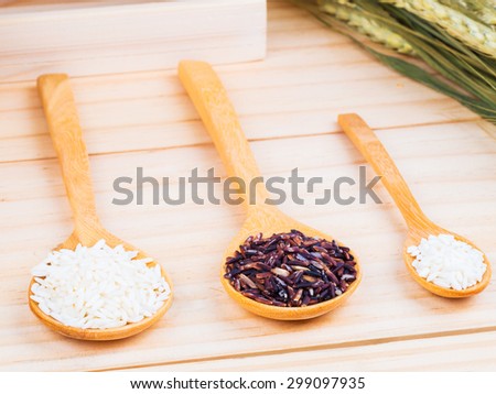 two types of milled rice on wooden spoons on table