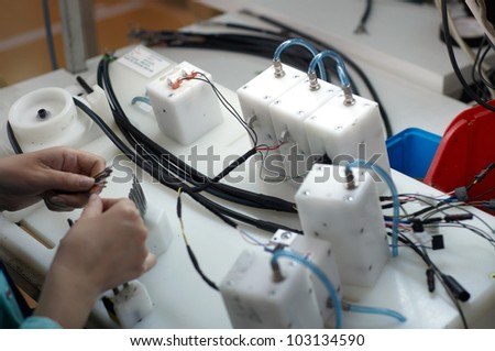 close up of worker hands in electrical cable production for Micro Electrc Mechanical Systems