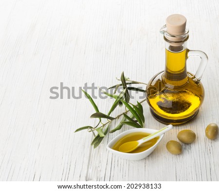 Olive oil and olive branch on the wooden table