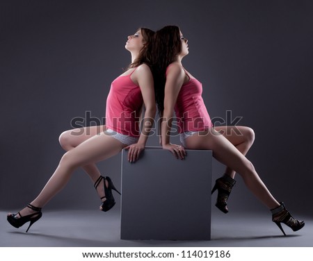 couple of sexy hot women posing on cube