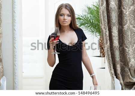 Sexy girl, tight black dress, posing in restaurant