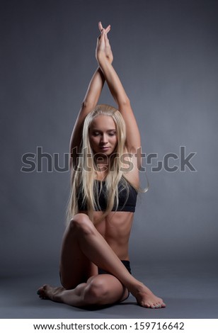 Image of becalmed blonde doing yoga in studio