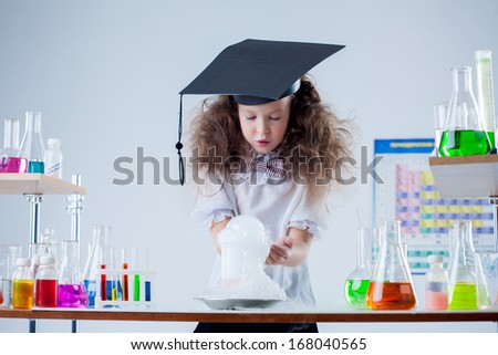 Curious girl watching result of experiment in lab