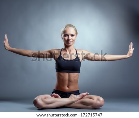 Beautiful slim woman doing yoga in studio